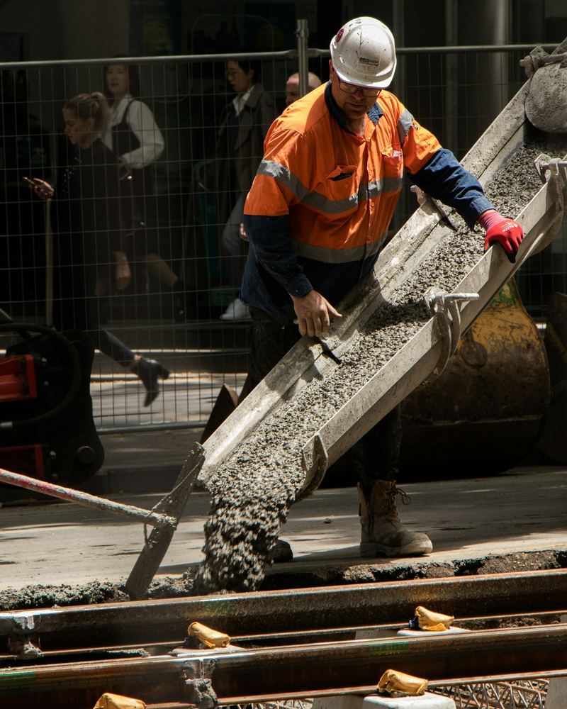 Crew member guiding a concrete chute (illustrative photo)