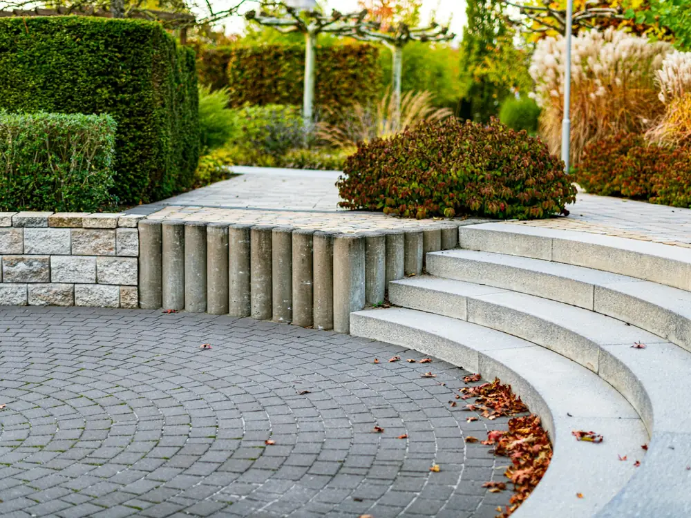Curved stone steps leading through a planted garden in autumn