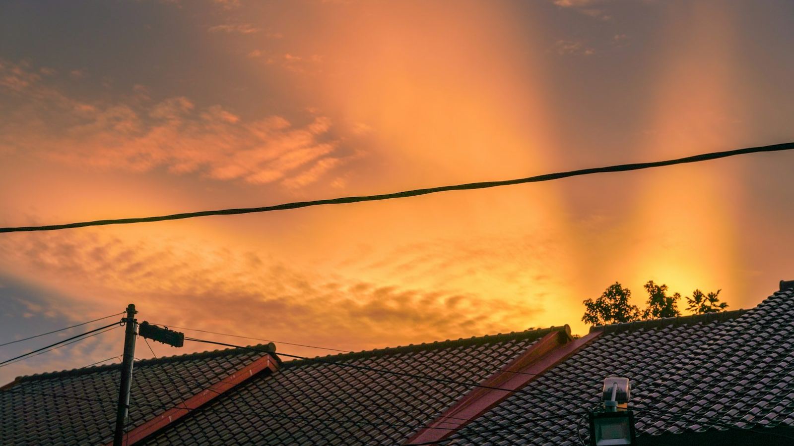 Sunset over neighborhood rooftops (illustrative photo)