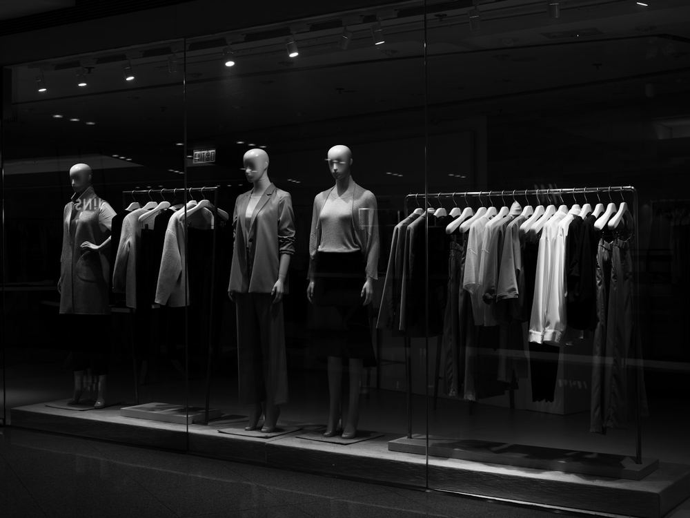 Night window display with clothing on mannequins (illustrative photo)