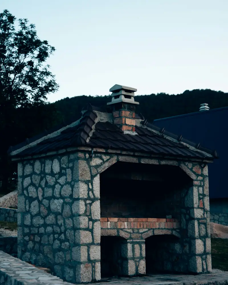 Stone outdoor fireplace and grill structure